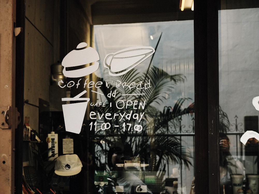 Opening hours and what a shop sells, hand painted on its window.